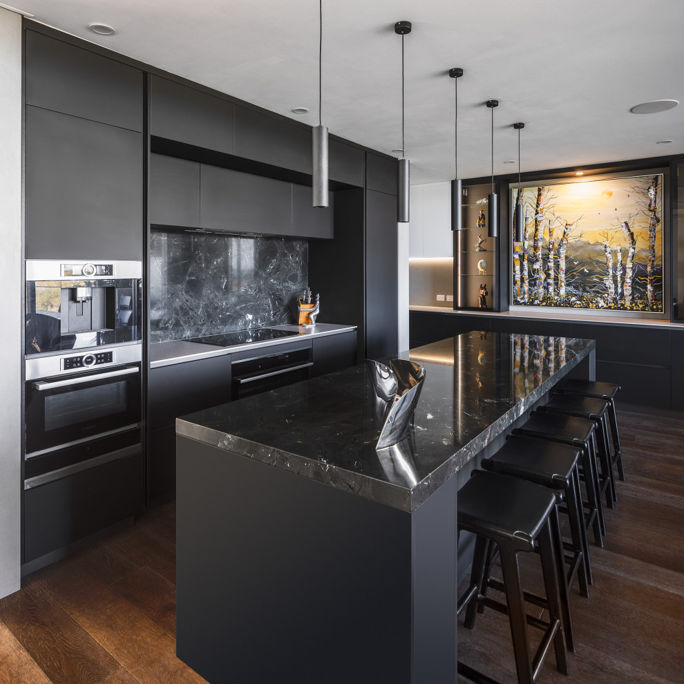 Inspiration for a large contemporary galley kitchen in Perth with black cabinets, granite benchtops, with island, black benchtop, flat-panel cabinets, black splashback, stone slab splashback, black appliances, dark hardwood floors and brown floor.