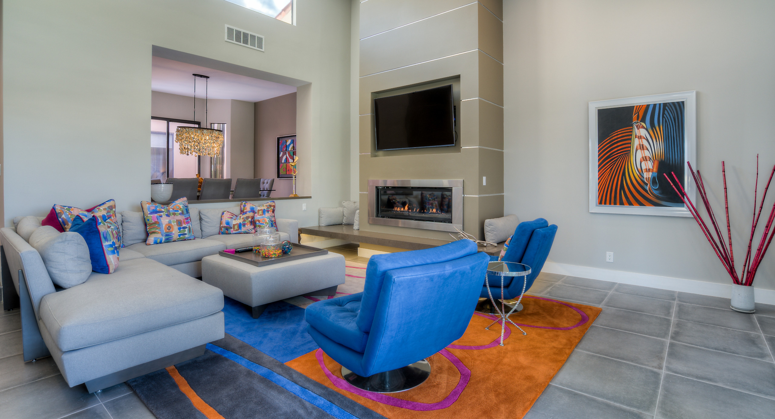 Living room has swivel chairs that can be used to enjoy the view of the golf course, or swivel back to be included in the room setting.  The use of strong colors add a sense of excitement and whimsy t