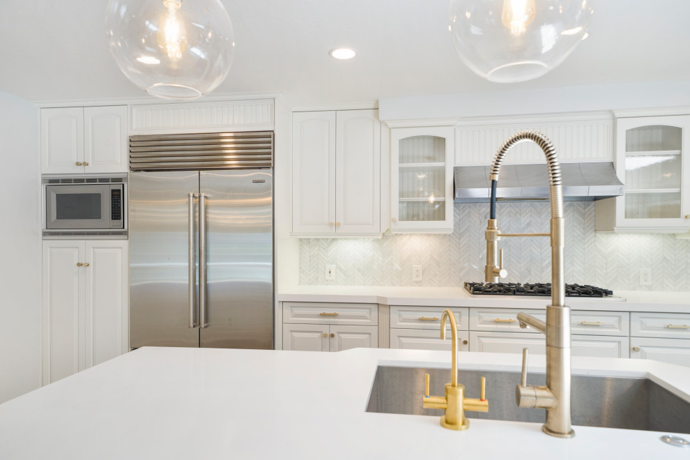 Example of a mid-sized transitional laminate floor and brown floor eat-in kitchen design in Orange County with an undermount sink, shaker cabinets, blue cabinets, quartz countertops, white backsplash, mosaic tile backsplash, stainless steel appliances, an island and white countertops
