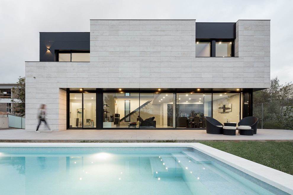 Mid-sized modern two-storey house exterior in Barcelona with stone veneer and a flat roof.