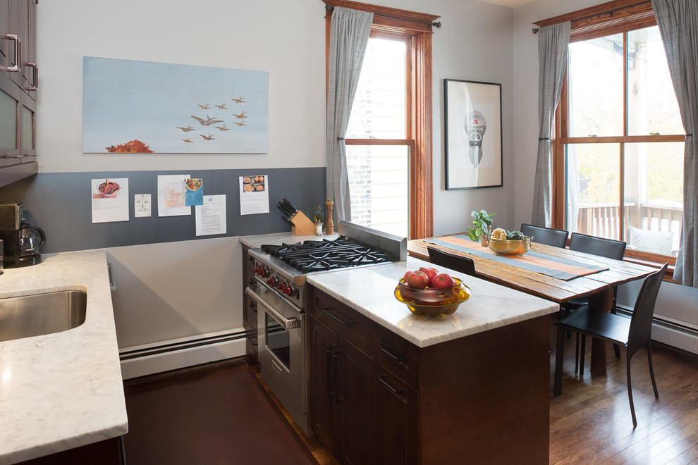 Inspiration for a small transitional u-shaped dark wood floor enclosed kitchen remodel in Chicago with an undermount sink, furniture-like cabinets, dark wood cabinets, marble countertops, white backsplash, metal backsplash, stainless steel appliances, blue walls and a peninsula