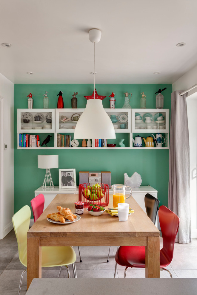 Photo of an eclectic separate dining room in Kent with green walls, no fireplace and grey floor.