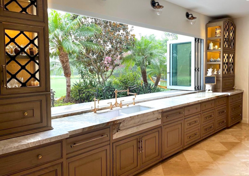 This is an example of an expansive mediterranean u-shaped eat-in kitchen in San Diego with a farmhouse sink, raised-panel cabinets, beige cabinets, marble benchtops, green splashback, marble splashback, stainless steel appliances, travertine floors, with island, beige floor and green benchtop.