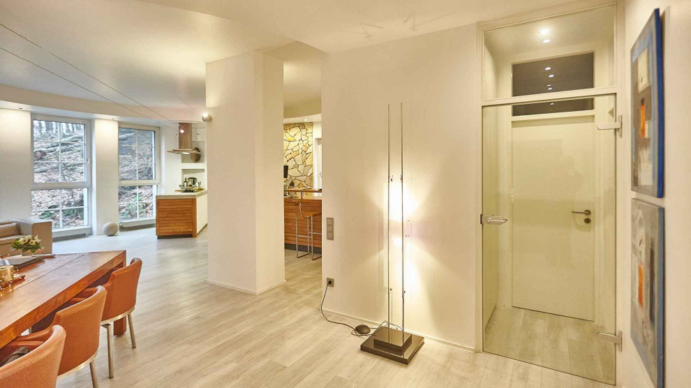 Modelo de salón para visitas abierto mediterráneo extra grande con paredes blancas, suelo vinílico, televisor colgado en la pared y suelo blanco