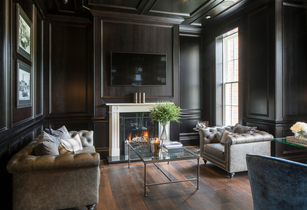 Design ideas for a mid-sized transitional enclosed family room in Berkshire with black walls, dark hardwood floors, a standard fireplace, a stone fireplace surround, a wall-mounted tv and brown floor.