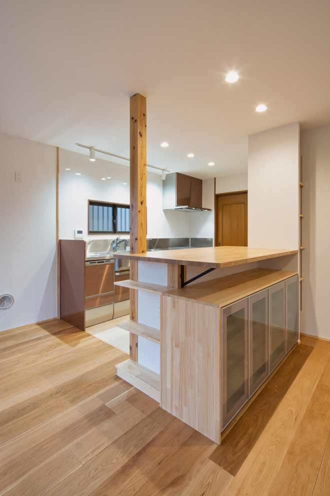 Photo of a medium sized scandinavian single-wall open plan kitchen in Tokyo Suburbs with an integrated sink, brown cabinets, stainless steel worktops, white splashback, stainless steel appliances, medium hardwood flooring, no island and a wallpapered ceiling.