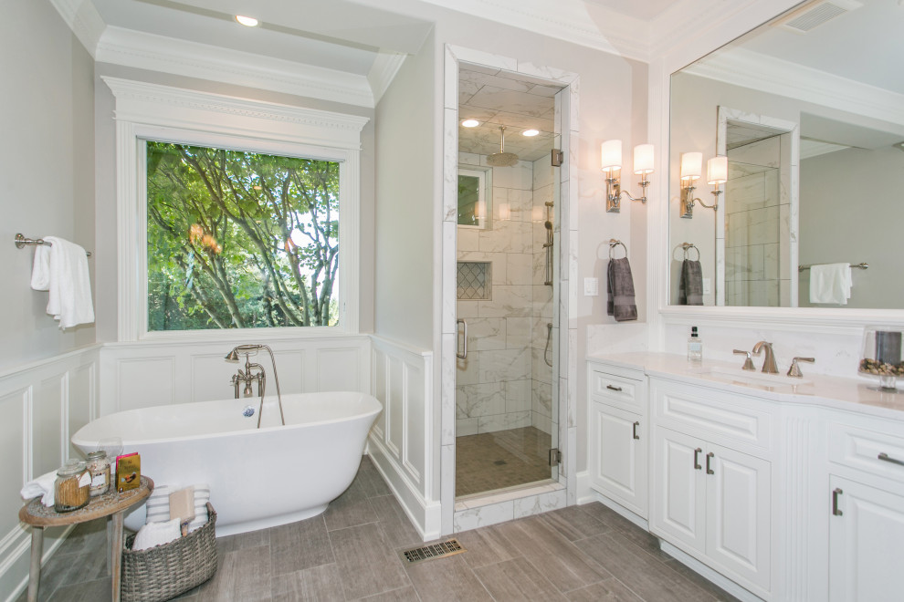 Large traditional master bathroom in Portland with raised-panel cabinets, white cabinets, a freestanding tub, white tile, marble, grey walls, ceramic floors, an undermount sink, engineered quartz benchtops, grey floor, a hinged shower door, white benchtops, a double shower, a double vanity and a built-in vanity.