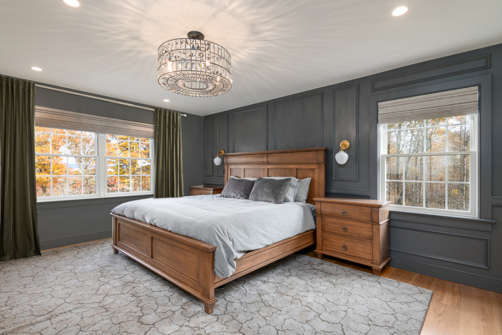 На фото: хозяйская спальня среднего размера в классическом стиле с серыми стенами, светлым паркетным полом, коричневым полом и панелями на части стены с