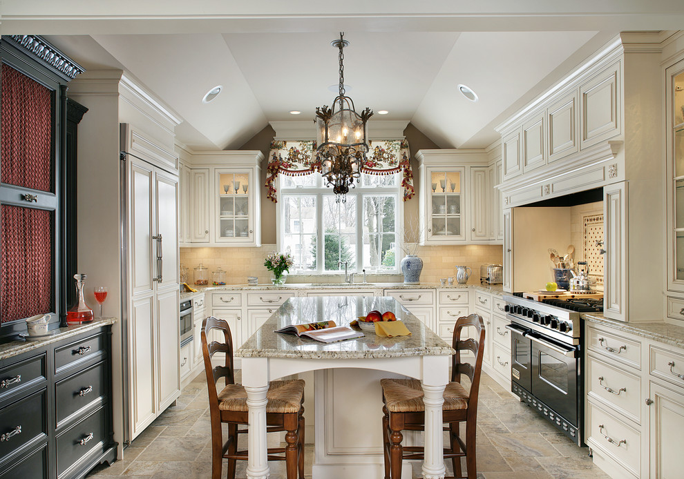 This is an example of a traditional u-shaped separate kitchen in New York with an undermount sink, beaded inset cabinets, beige cabinets, granite benchtops, beige splashback, limestone floors, with island and panelled appliances.