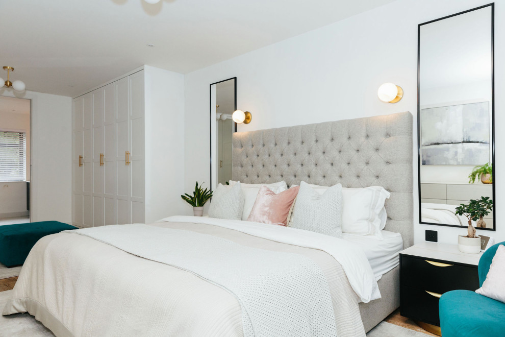 Diseño de dormitorio principal y gris y blanco clásico renovado de tamaño medio con paredes blancas, suelo de madera en tonos medios y suelo beige