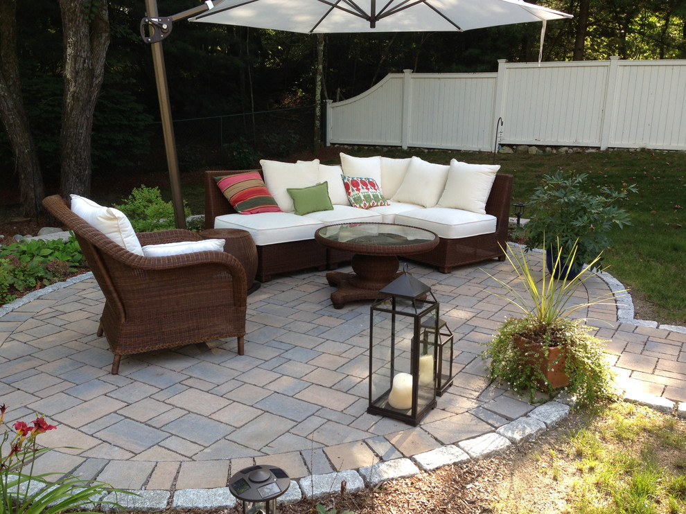 Mid-sized contemporary backyard patio in Providence with natural stone pavers and an awning.