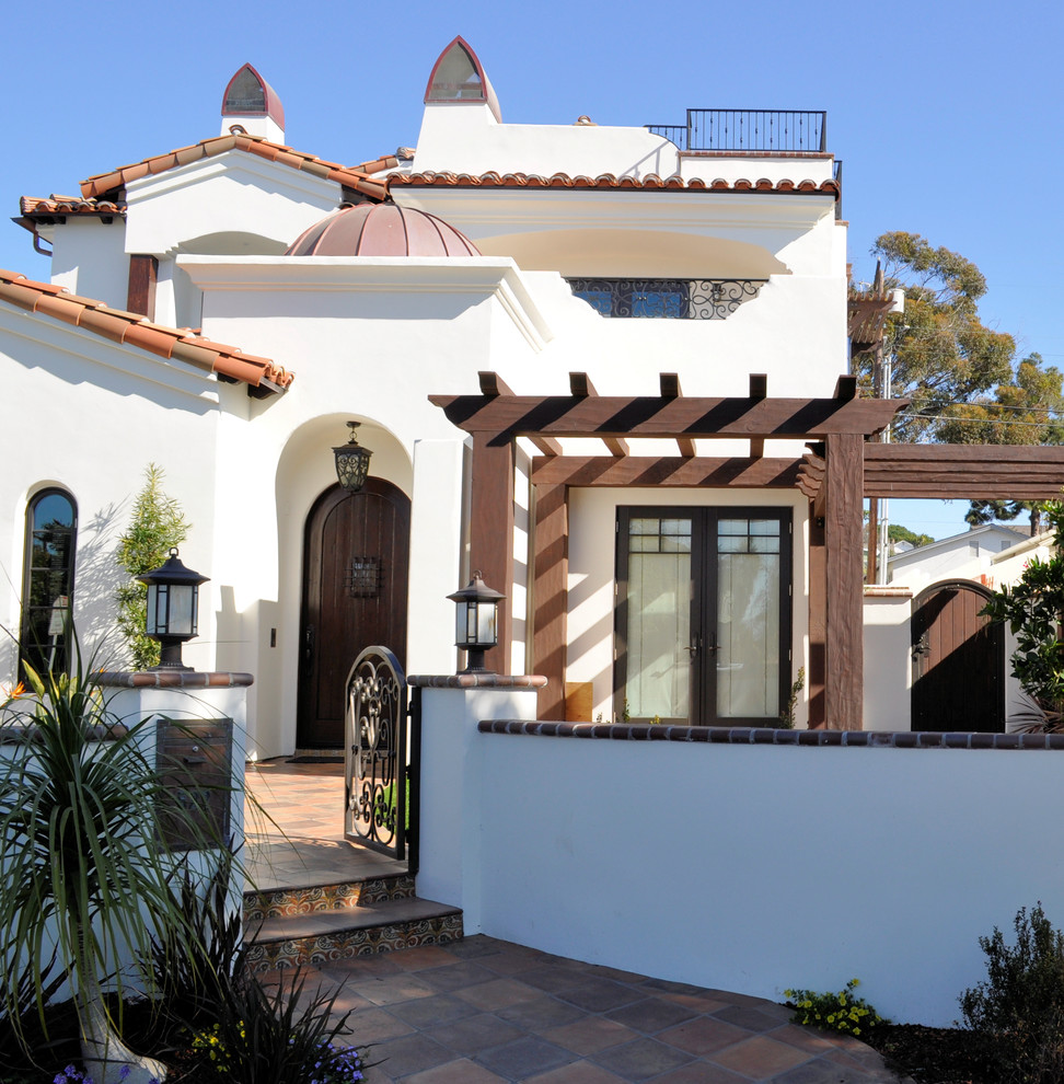 Design ideas for a mid-sized mediterranean three-storey stucco white house exterior in San Diego with a flat roof.