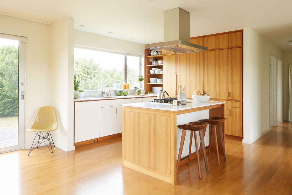 Inspiration for a midcentury kitchen in Seattle with a single-bowl sink, flat-panel cabinets, medium wood cabinets, marble benchtops, panelled appliances, medium hardwood floors, with island, window splashback and orange floor.