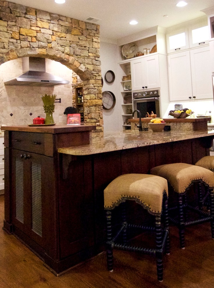 Eat-in kitchen - large rustic u-shaped medium tone wood floor eat-in kitchen idea with an undermount sink, shaker cabinets, medium tone wood cabinets, granite countertops, beige backsplash, stone tile backsplash, stainless steel appliances and an island