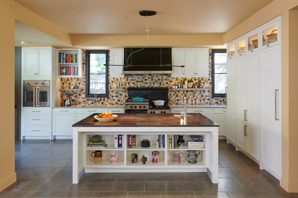 Inspiration for a traditional l-shaped eat-in kitchen in DC Metro with an undermount sink, flat-panel cabinets, white cabinets, zinc benchtops, multi-coloured splashback, stone tile splashback, stainless steel appliances, limestone floors, with island, grey floor and grey benchtop.