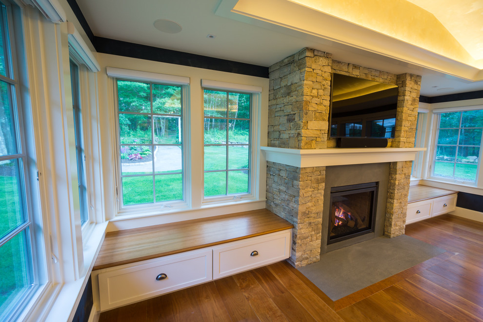 This is an example of a large transitional enclosed family room in Providence with blue walls, dark hardwood floors, a standard fireplace, a stone fireplace surround and a wall-mounted tv.