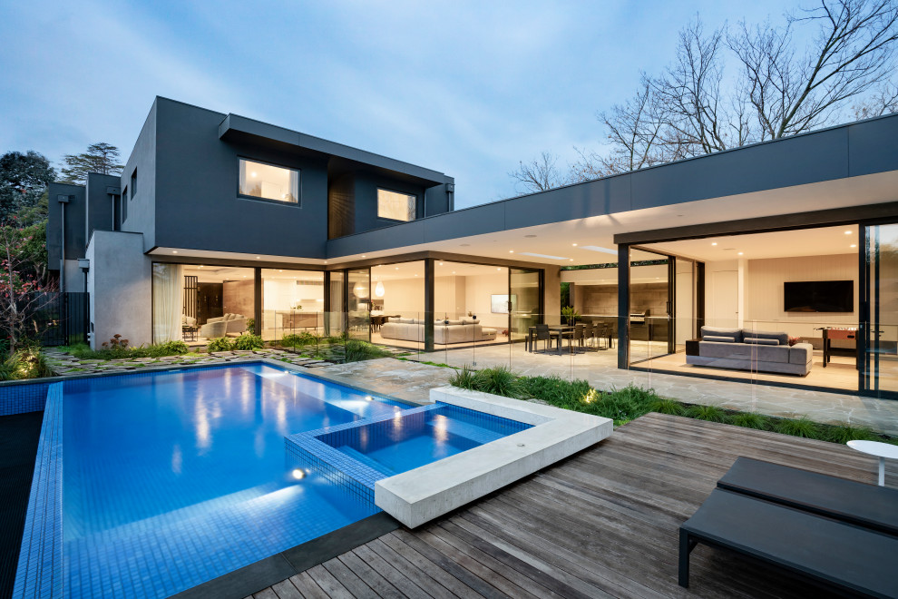 Contemporary backyard rectangular pool in Melbourne with a hot tub and decking.