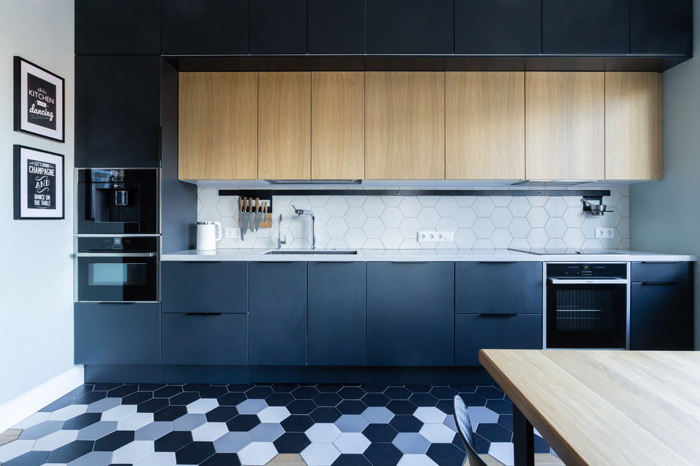This is an example of a large contemporary single-wall eat-in kitchen in Moscow with an undermount sink, flat-panel cabinets, black cabinets, quartz benchtops, white splashback, ceramic splashback, black appliances, ceramic floors, no island, white benchtop and multi-coloured floor.
