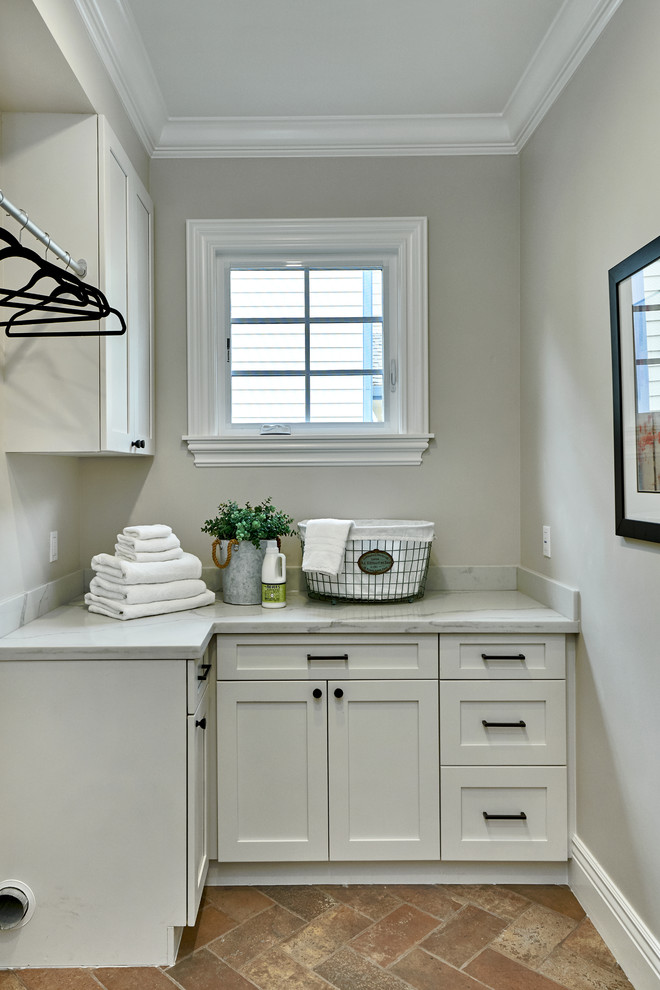 Inspiration for a small mediterranean l-shaped dedicated laundry room in San Francisco with shaker cabinets, white cabinets, quartz benchtops, grey walls, porcelain floors, a side-by-side washer and dryer, red floor and white benchtop.