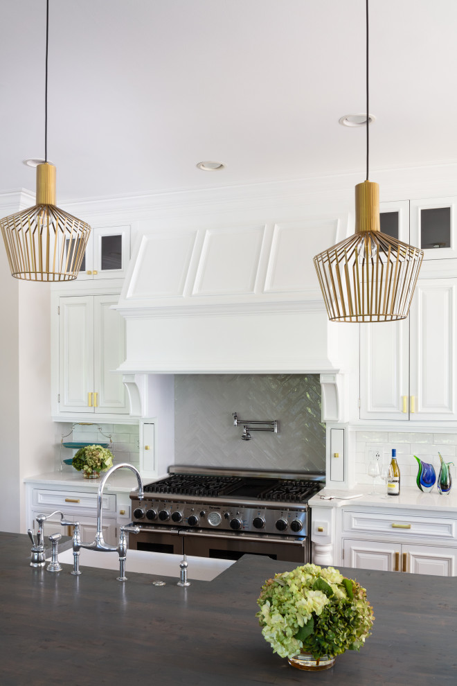 Inspiration for a large transitional u-shaped dark wood floor and brown floor eat-in kitchen remodel in Atlanta with a farmhouse sink, recessed-panel cabinets, white cabinets, quartz countertops, white backsplash, ceramic backsplash, stainless steel appliances, an island and white countertops