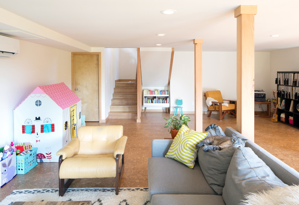 This is an example of a mid-sized midcentury walk-out basement in Seattle with white walls, cork floors and brown floor.