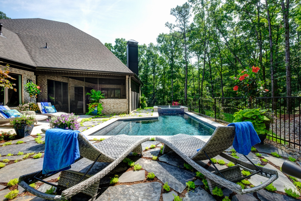 Design ideas for a mid-sized transitional backyard l-shaped pool in Little Rock with a hot tub and natural stone pavers.
