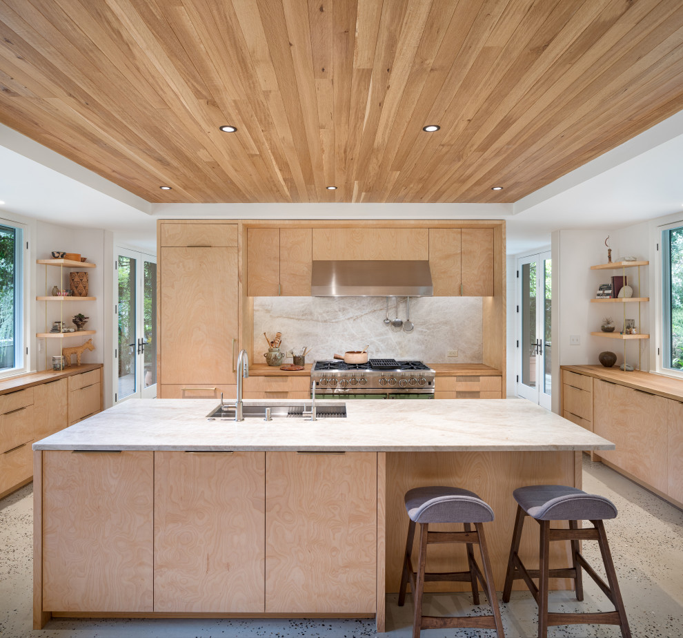 Example of a huge minimalist u-shaped concrete floor, gray floor and wood ceiling kitchen design in Portland with an undermount sink, flat-panel cabinets, light wood cabinets, quartzite countertops, gray backsplash, stone slab backsplash, paneled appliances, an island and gray countertops