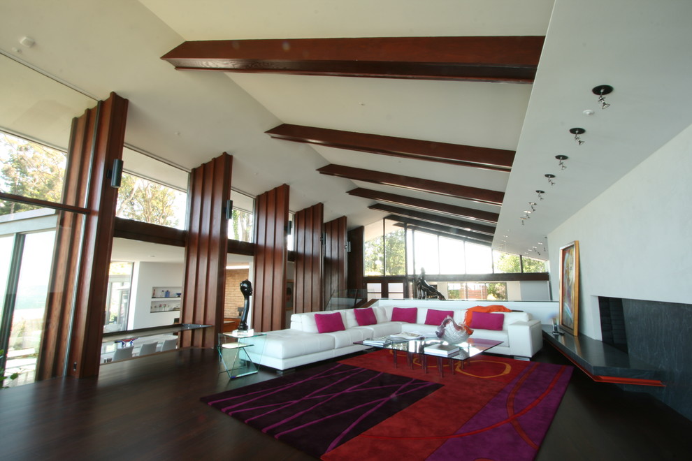 This is an example of a large modern open concept living room in San Francisco with white walls, dark hardwood floors, a standard fireplace and a stone fireplace surround.