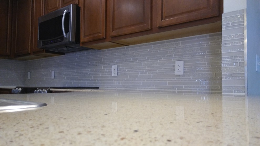 Inspiration for a mid-sized transitional l-shaped eat-in kitchen remodel with quartz countertops, white backsplash, glass tile backsplash and a peninsula