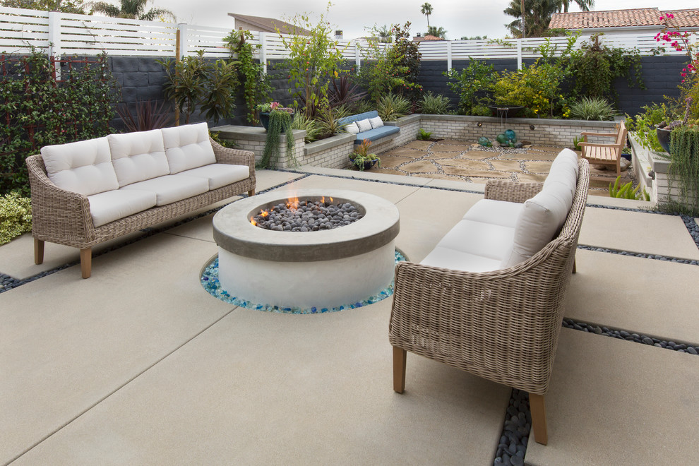 Design ideas for a mid-sized transitional backyard partial sun formal garden for summer in Los Angeles with a fire feature and concrete pavers.