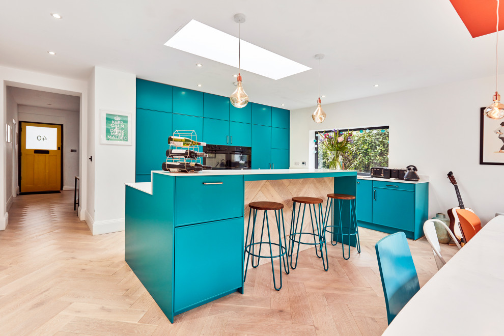 Photo of a mid-sized contemporary l-shaped eat-in kitchen in Other with a drop-in sink, recessed-panel cabinets, blue cabinets, quartzite benchtops, white splashback, black appliances, laminate floors, with island, beige floor, white benchtop and vaulted.
