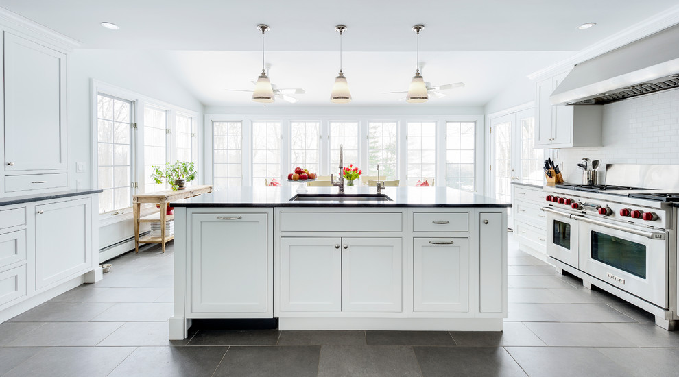 Transitional eat-in kitchen in New York with an undermount sink, beaded inset cabinets, white cabinets, granite benchtops, white splashback, subway tile splashback, stainless steel appliances, porcelain floors and with island.