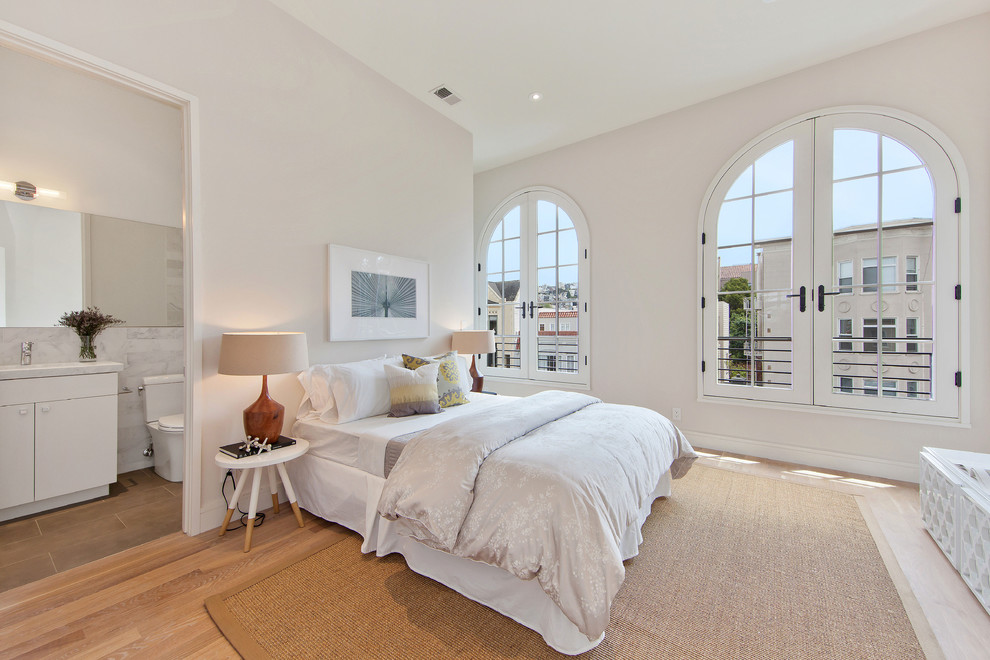 Photo of a mid-sized transitional master bedroom in San Francisco with white walls and light hardwood floors.