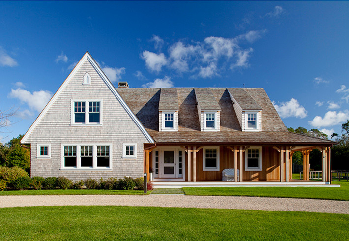Photo of a large country two-storey grey house exterior in Boston with wood siding, a gable roof and a shingle roof.
