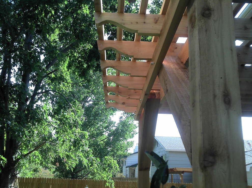 Mid-sized mountain style backyard deck photo in Denver with a pergola