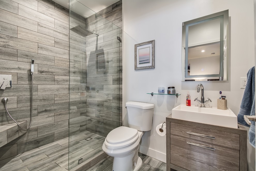 Inspiration for a small contemporary 3/4 bathroom in Los Angeles with a two-piece toilet, ceramic floors, grey floor, an open shower, flat-panel cabinets, grey cabinets, an alcove shower, gray tile and a vessel sink.