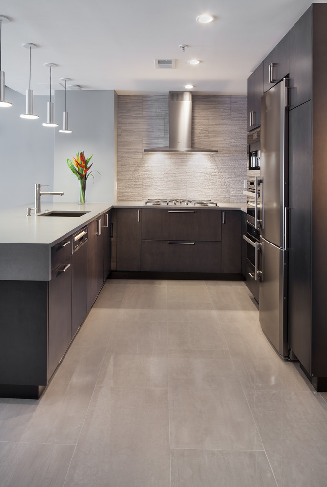 Design ideas for a mid-sized contemporary u-shaped open plan kitchen in DC Metro with an undermount sink, flat-panel cabinets, dark wood cabinets, solid surface benchtops, grey splashback, stone tile splashback, stainless steel appliances, porcelain floors and with island.