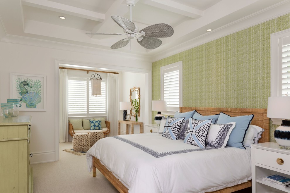 Large tropical master bedroom in Miami with green walls, carpet and beige floor.