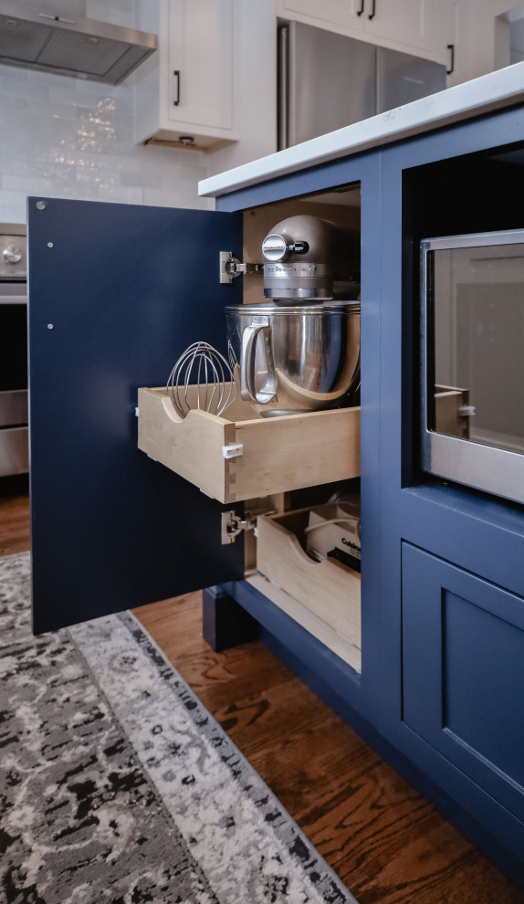 Example of a small transitional u-shaped medium tone wood floor and brown floor eat-in kitchen design in Ottawa with an undermount sink, shaker cabinets, white cabinets, quartz countertops, white backsplash, subway tile backsplash, stainless steel appliances, an island and white countertops