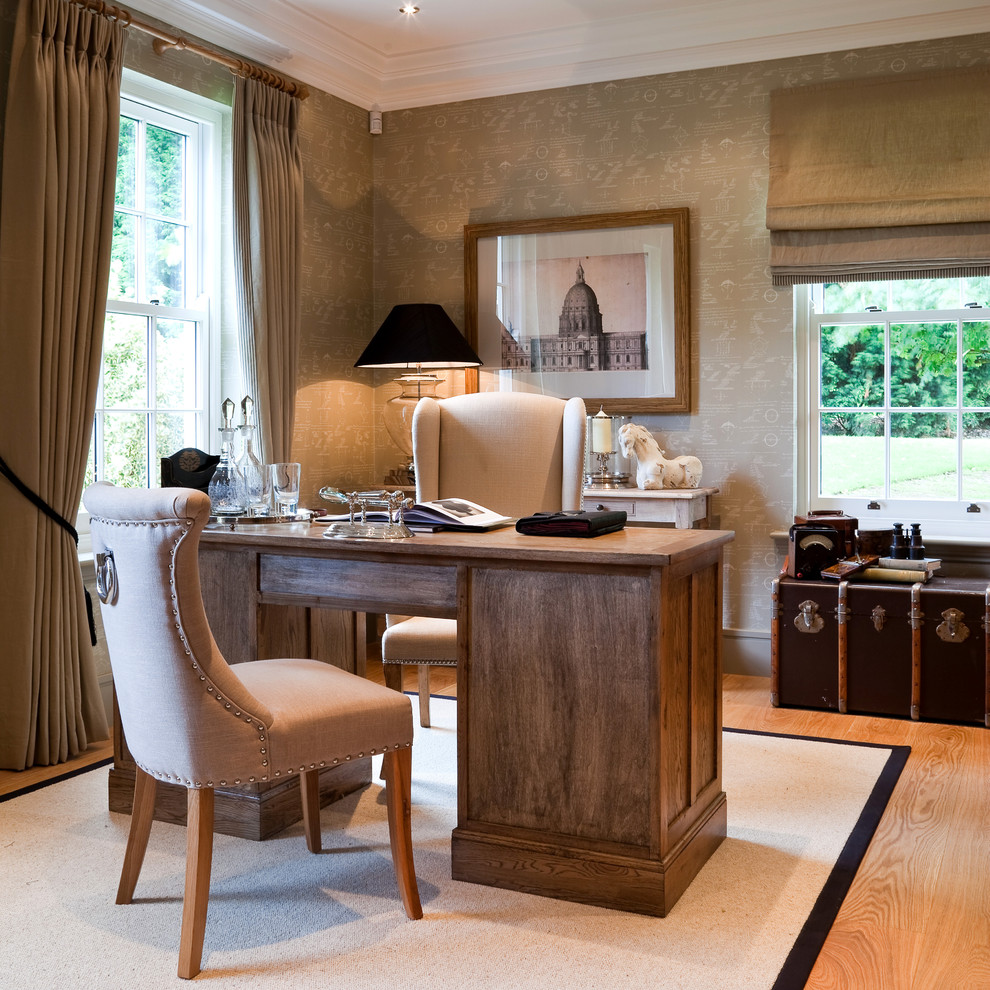 This is an example of a traditional study room in Berkshire with beige walls, light hardwood floors and a freestanding desk.