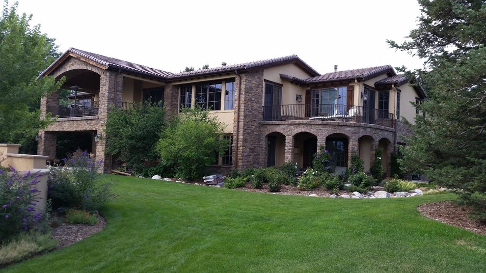 This is an example of an expansive arts and crafts two-storey beige exterior in Denver with mixed siding.