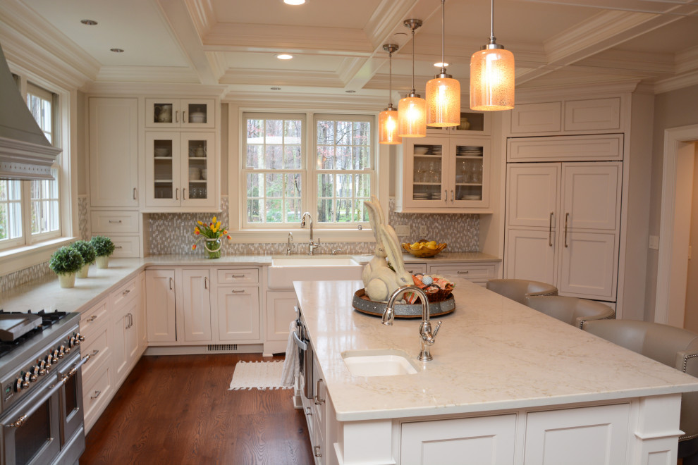Design ideas for a large transitional u-shaped separate kitchen in Baltimore with a farmhouse sink, recessed-panel cabinets, white cabinets, quartz benchtops, grey splashback, panelled appliances, dark hardwood floors, with island, brown floor, white benchtop and coffered.