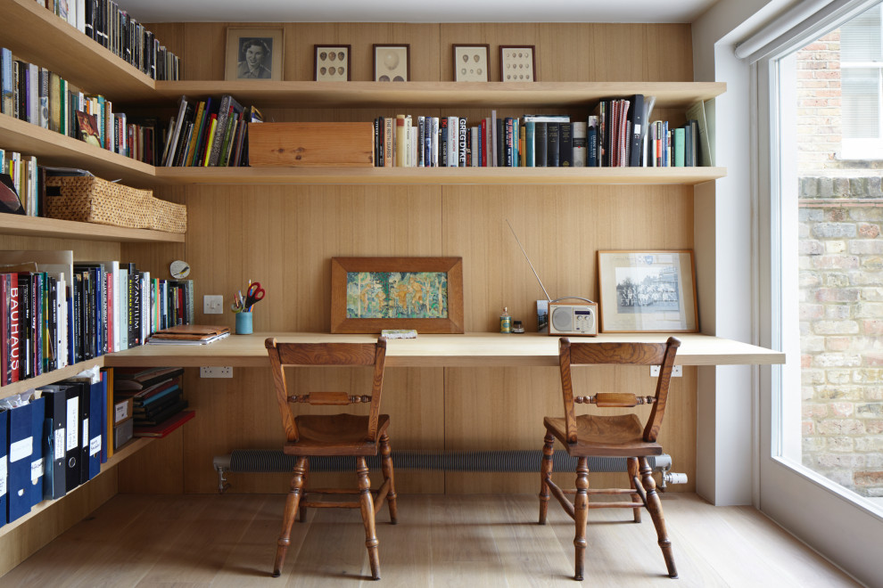 Mid-sized transitional study room in London with medium hardwood floors, a built-in desk and panelled walls.