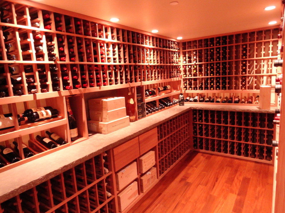 This is an example of a large country wine cellar in Los Angeles with light hardwood floors, storage racks and orange floor.