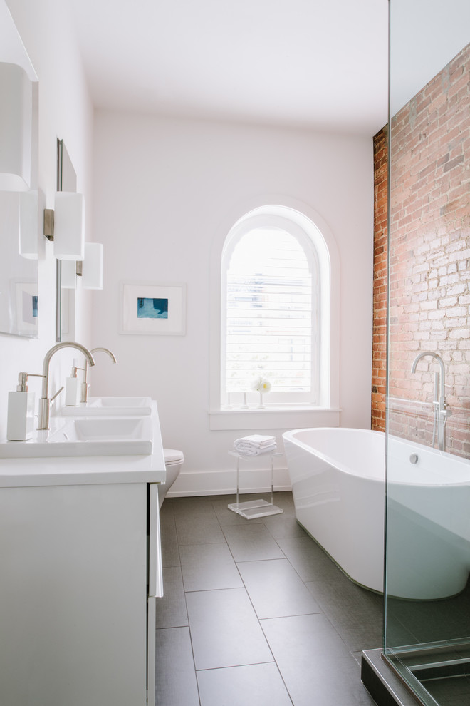 Inspiration for a mid-sized contemporary master bathroom in DC Metro with white cabinets, a drop-in tub, a corner shower, white walls, a drop-in sink, black floor, white benchtops, flat-panel cabinets, porcelain floors, solid surface benchtops and a hinged shower door.