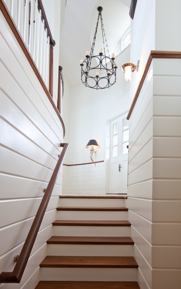 Photo of a beach style wood straight staircase in Boston with painted wood risers.