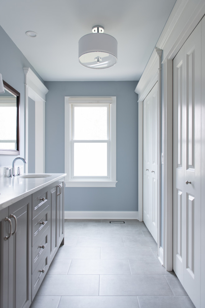 Aménagement d'une salle de bain principale classique de taille moyenne avec un placard à porte shaker, des portes de placard grises, une douche double, WC séparés, un carrelage blanc, des carreaux de porcelaine, un mur bleu, un sol en carrelage de porcelaine, un lavabo encastré, un plan de toilette en quartz modifié, un sol gris, une cabine de douche à porte coulissante, un plan de toilette blanc, une niche, meuble double vasque et meuble-lavabo sur pied.