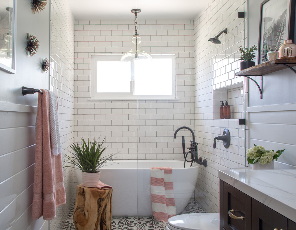 Inspiration for a mid-sized country 3/4 bathroom in Los Angeles with shaker cabinets, brown cabinets, a freestanding tub, a curbless shower, a two-piece toilet, white tile, subway tile, grey walls, cement tiles, an undermount sink, marble benchtops, black floor and an open shower.