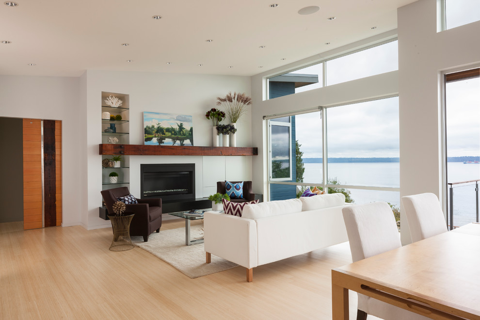 Photo of a mid-sized contemporary formal open concept living room in Seattle with white walls, light hardwood floors, a ribbon fireplace, a metal fireplace surround, no tv and beige floor.