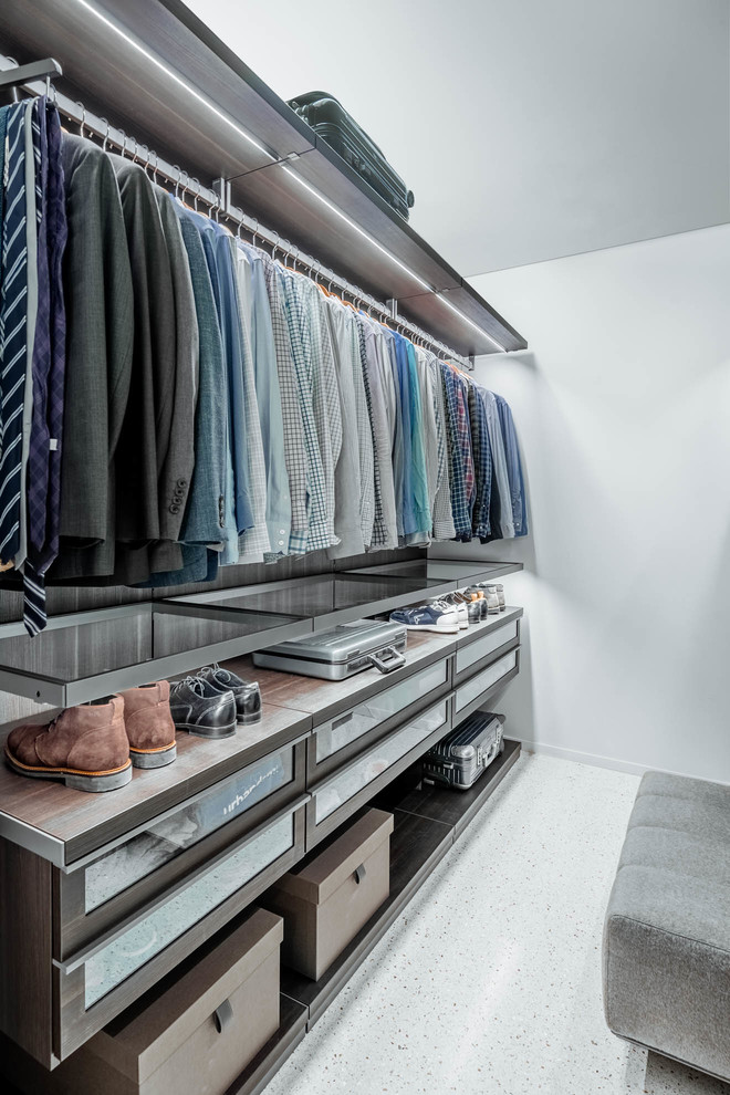 Photo of a large modern men's walk-in wardrobe in Other with glass-front cabinets, dark wood cabinets, laminate floors and white floor.
